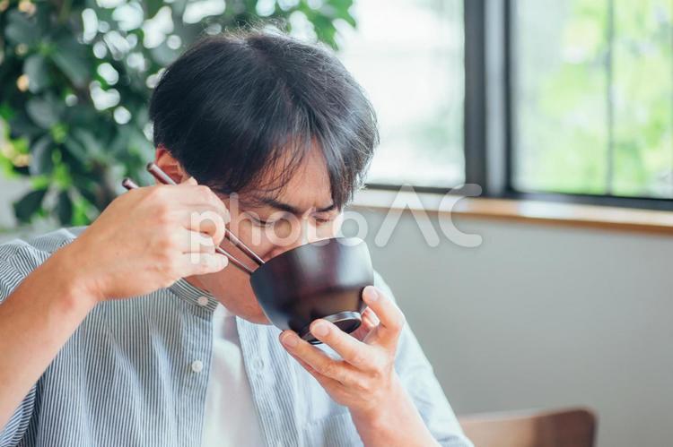 温かい汁を飲む男性（味噌汁、スープ） 味噌汁,みそ汁,汁物の写真素材