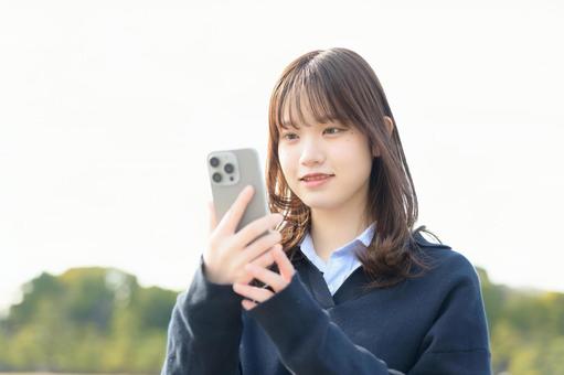 スマホを操作する女子高生 スマホを操作する女子高生 女子高生,電話,登校の写真素材