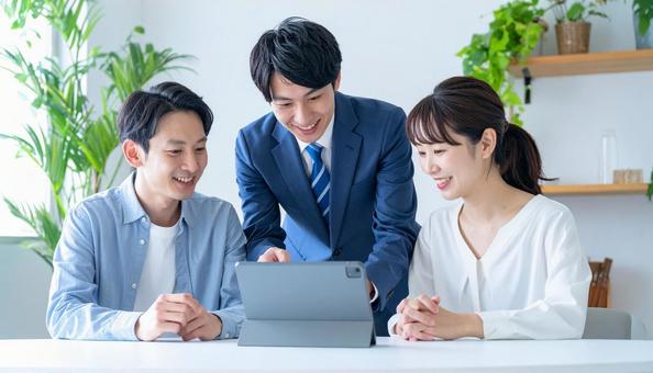 タブレットを使って説明する男性営業マン タブレットを使って説明する男性営業マンの写真