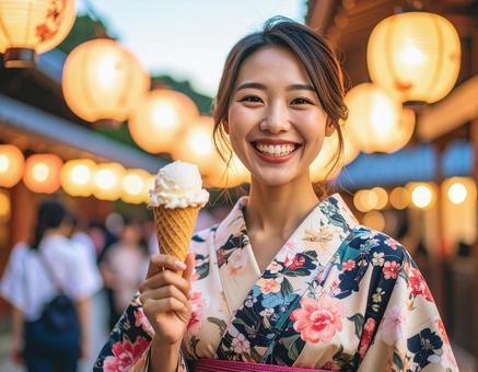 夏祭りでアイスクリームを持つ笑顔の女性 夏祭りでアイスクリームを持つ笑顔の女性の写真