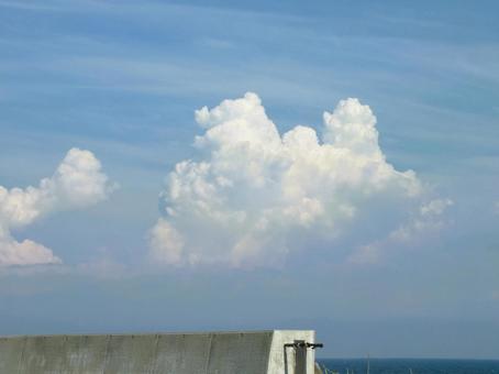 嵩上げ工事途中の防波堤と海 入道雲の夏 嵩上げ工事途中の防波堤と海 入道雲の夏の写真