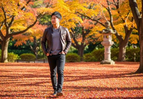 紅葉の遊歩道を歩く革ジャンの男性 紅葉の遊歩道を歩く革ジャンの男性の写真