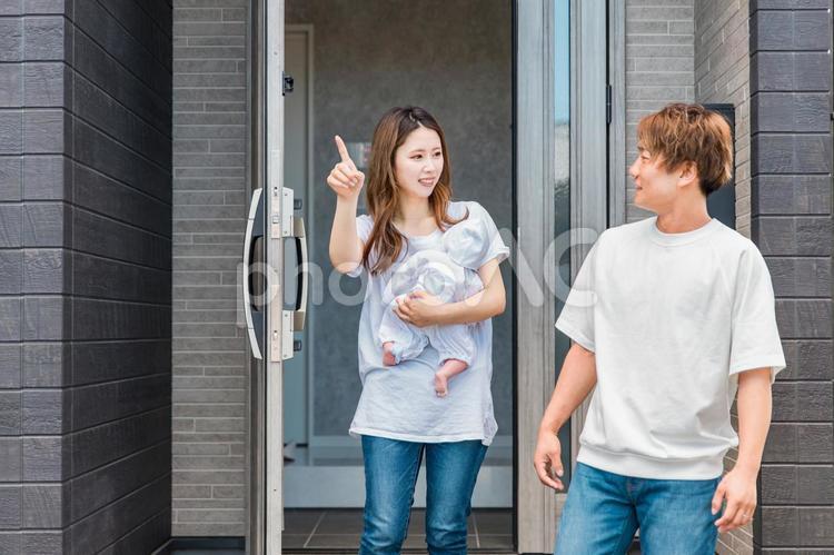 散歩に出かける赤ちゃんを抱っこした夫婦 玄関,子育て,家の写真素材