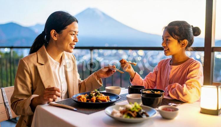 食事のテーブルに座って食べる母と女の子 食べ物,食事,ランチの写真素材