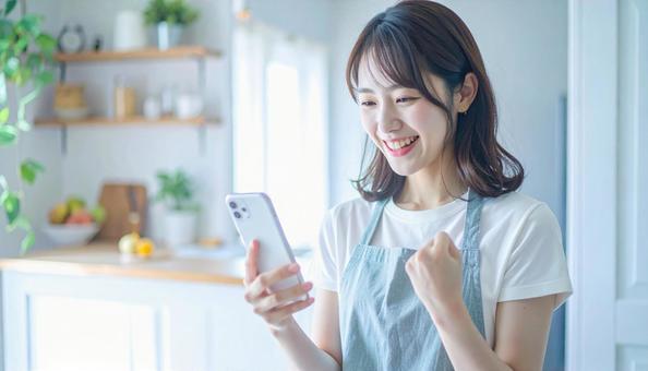 スマホでポイ活する笑顔の女性 スマホでポイ活する笑顔の女性の写真