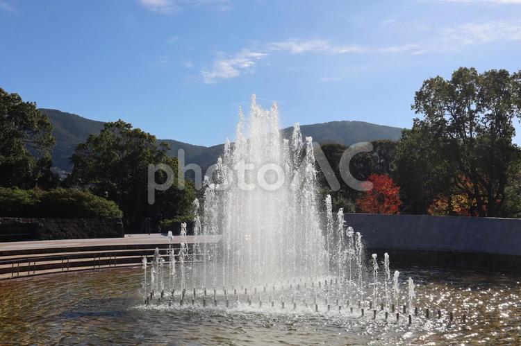青空と山並みの見える噴水のある公園の風景 噴水,青空,山並みの写真素材