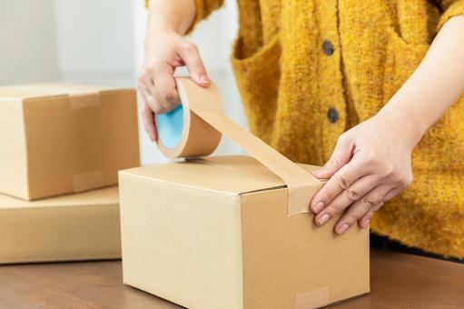 段ボールを梱包する手元 段ボール,ガムテープ,留めるの写真素材