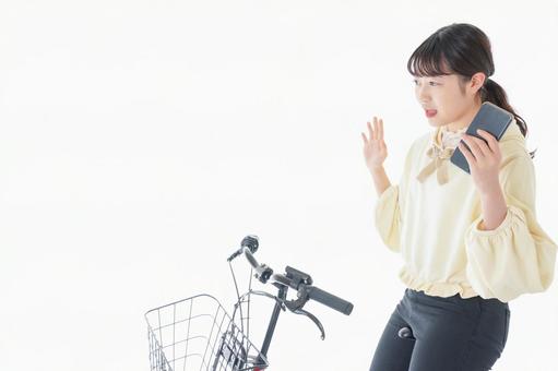 自転車でスマホを使う若い女性 自転車でスマホを使う若い女性 地図,ながら運動,マナー違反の写真素材