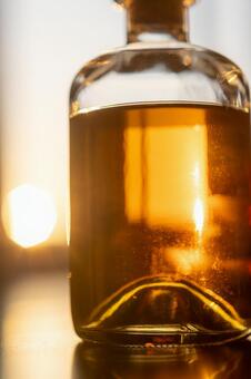 琥珀色のウイスキーと夕日_縦 ウィスキー,ボトル,琥珀色の写真素材