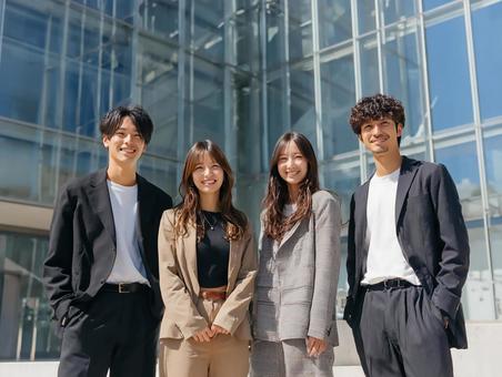 オフィスビル前で笑顔のビジネスパーソン オフィスビル前で笑顔のビジネスパーソンの写真