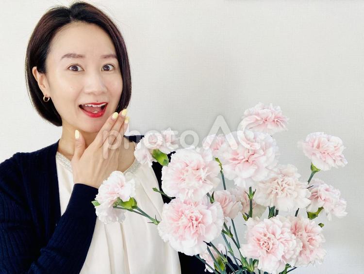 母の日に花束をもらって喜ぶ女性 女性,笑顔,花束の写真素材