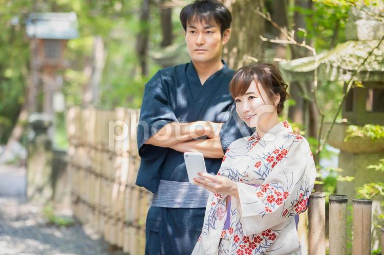 スマホを持つ浴衣姿の男女 浴衣,アプリ,カップルの写真素材
