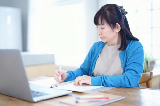 ノートを取りながら真剣に学ぶ女性 ノートを取りながら真剣に学ぶ女性 主婦,家政婦,シニアの写真素材