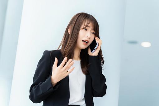 スマホで話す困った表情の女性 スマホで話す困った表情の女性 女性,スマホ,スマートフォンの写真素材