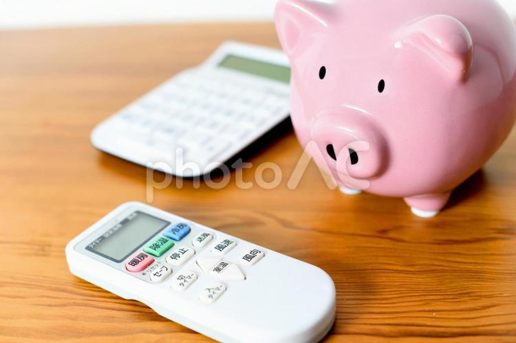 エアコンのリモコンと電卓と豚の貯金箱 電気料金,電気代,エアコンの写真素材