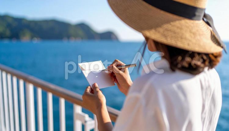 旅先で手紙をしたためる女性 手紙,大人,絵葉書の写真素材