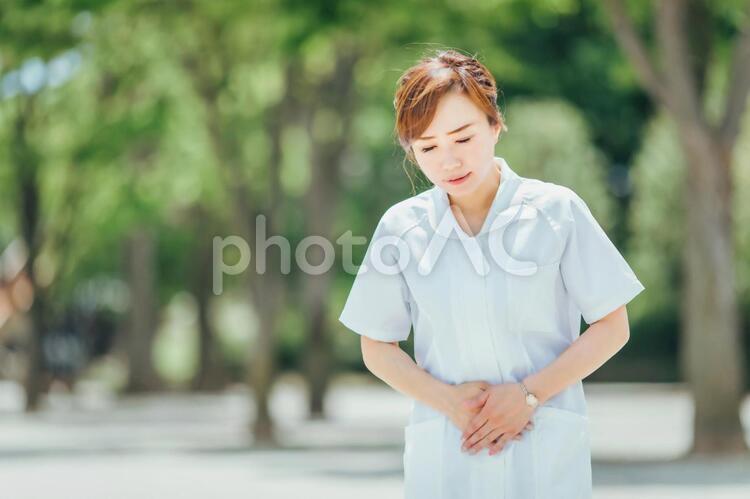 体調不良の白衣の女性 腹痛,お腹,下痢の写真素材