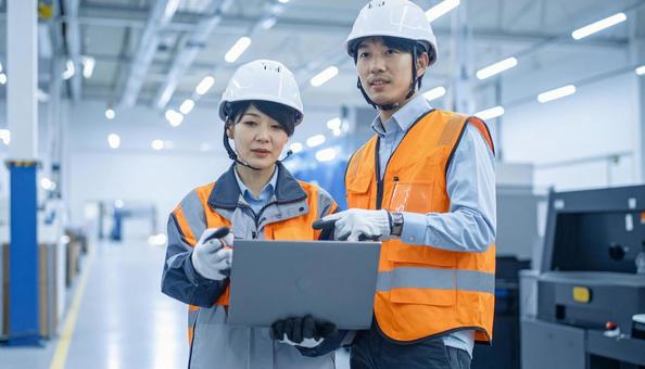 工場でタブレットで製品を検査する作業員 工場でタブレットで製品を検査する作業員の写真