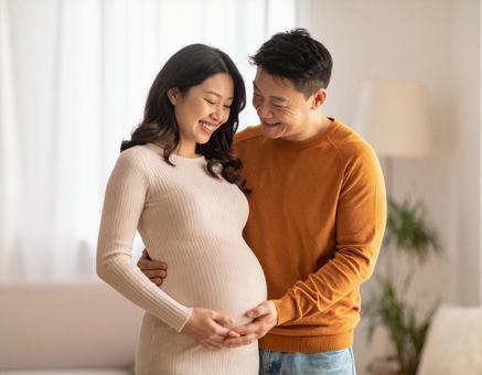 妊娠中の妻と幸せそうに寄り添う夫婦 妊娠中の妻と幸せそうに寄り添う夫婦の写真