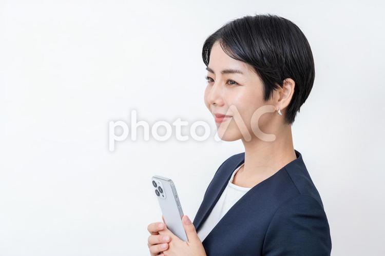 スマホを持つビジネスウーマン。 スマホ,スマートフォン,女性の写真素材