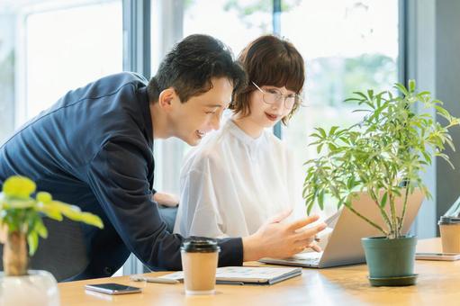 ミーティングをする男女2人のビジネスマン ミーティングをする男女2人のビジネスマンの写真