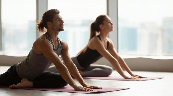 ジムでストレッチする男女の写真