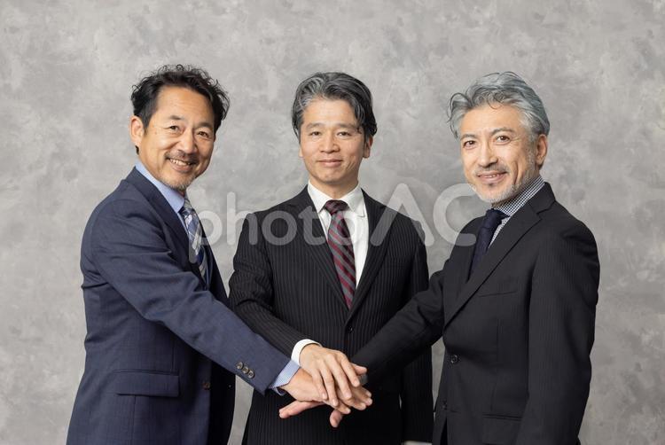 円陣で手を重ねるミドルエイジ男性 エグゼクティブ,ビジネスマン,円陣の写真素材