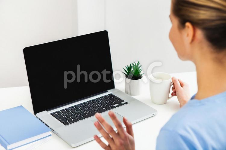マグを持つ女性とノートパソコン 女性,ノートパソコン,デスクワークの写真素材