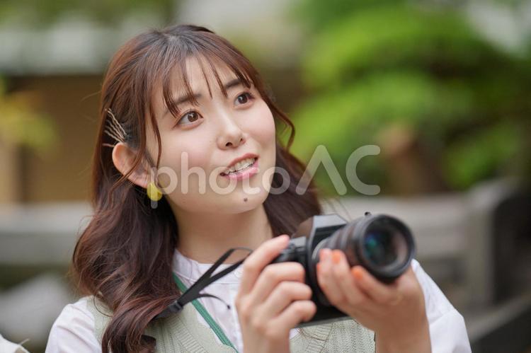 公園で一眼レフカメラを構えている女性 女子旅,女性,日本人の写真素材