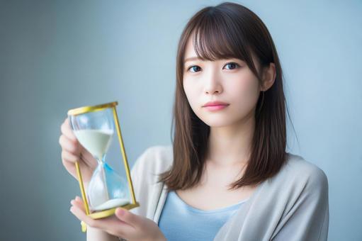 砂時計と女性 時間の大切さ 砂時計と女性 時間の大切さの写真