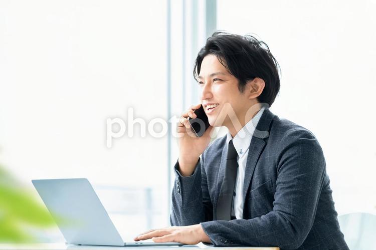スマホで通話をする笑顔の男性ビジネスマン 男性,スマホ,ビジネスの写真素材