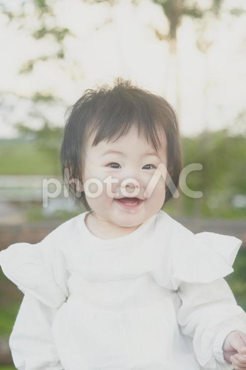公園で座り微笑む赤ちゃん 子供,女の子,悩みの写真素材