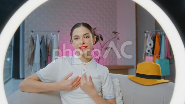 カメラ目線でリングライトをつけて配信する女性 女性,人物,インフルエンサーの写真素材
