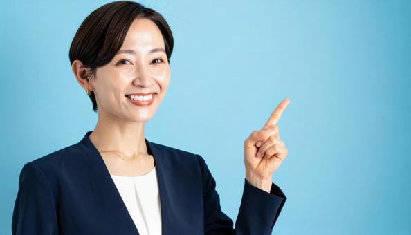 笑顔で指差すビジネスウーマンの写真