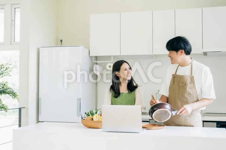 家事を手伝う男性と女性（パソコン） キッチン,夫婦,パソコンの写真素材