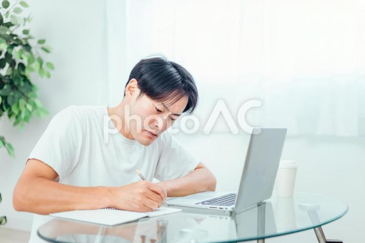 家でパソコンを使って勉強する男性（真剣） パソコン,資格,ノートパソコンの写真素材