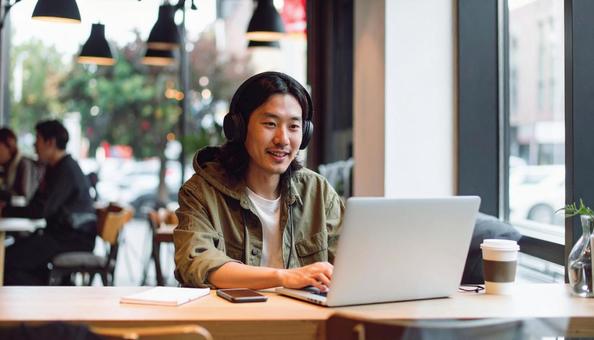 カフェで仕事をするフリーランス男性 カフェで仕事をするフリーランス男性の写真