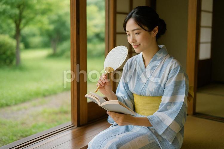 団扇をあおぎ読書する浴衣女性 浴衣,女性,団扇の写真素材