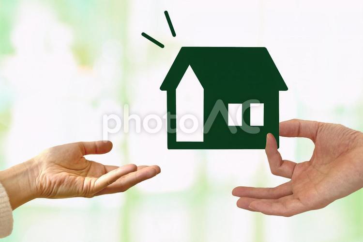 家を受け取る手とキラキラ背景 住宅,マイホーム,夫婦の写真素材