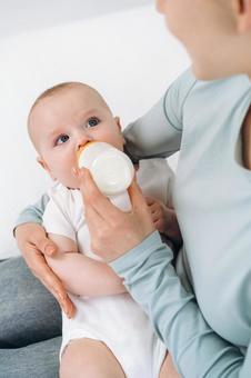 ミルクを飲みながら母の方を見る赤ちゃん ミルクを飲みながら母の方を見る赤ちゃん 赤ちゃん,哺乳瓶,飲むの写真素材