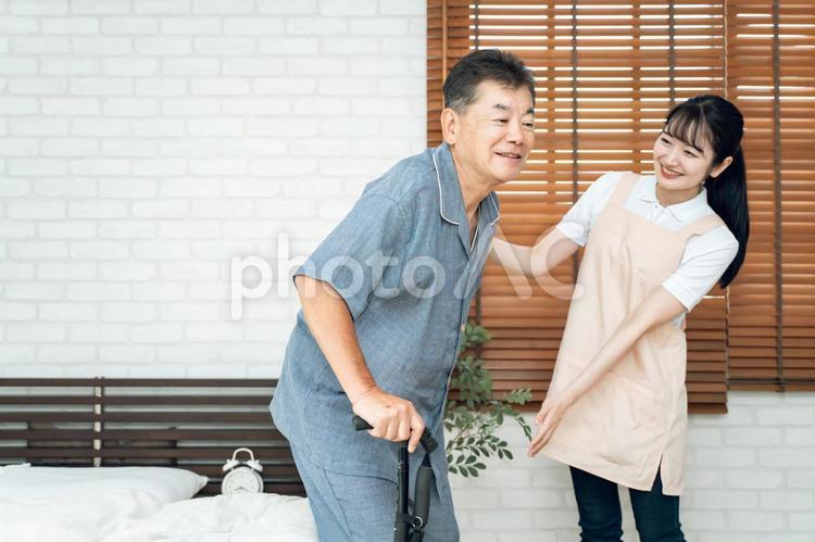 杖を使う高齢者男性と女性スタッフ 訪問介護,介護,高齢者の写真素材