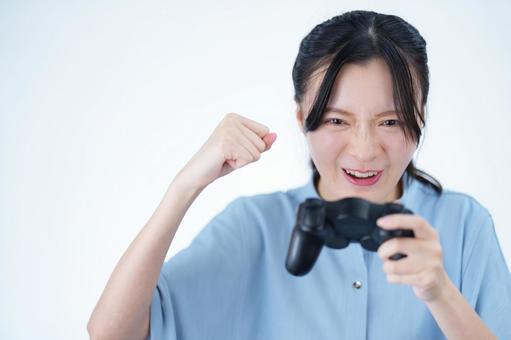女性がゲームコントローラーを持ってガッツポーズする 女性,ゲーム,コントローラーの写真素材
