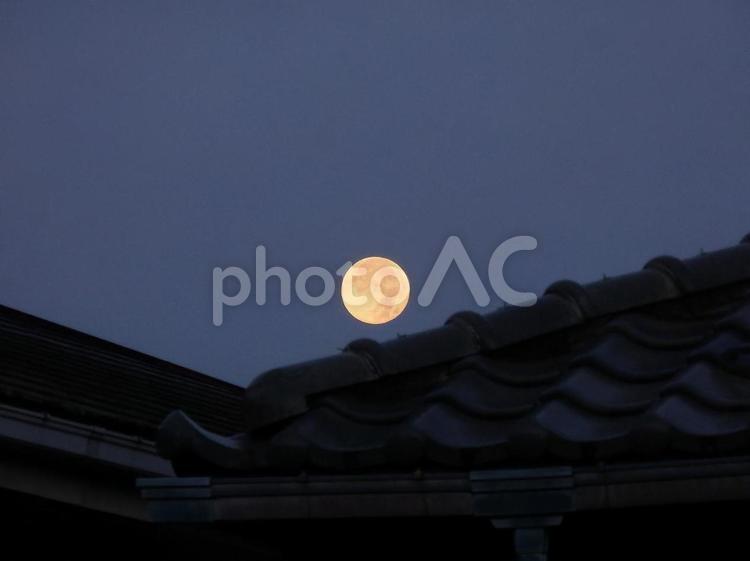 【空の写真】屋根の間に沈む満月 自然,風景,風景写真の写真素材