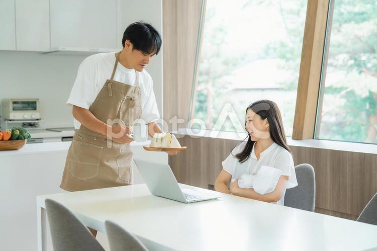 出産後に仕事する女性と家事をする男性 赤ちゃん,出産,リモートワークの写真素材