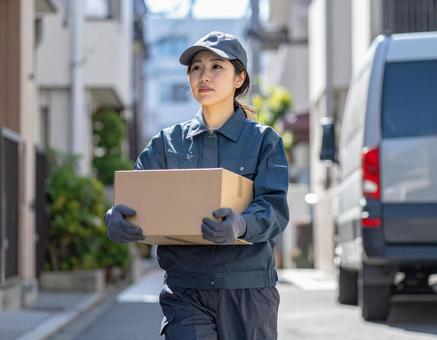 宅配ドライバーとして頑張る女性の配達風景の写真
