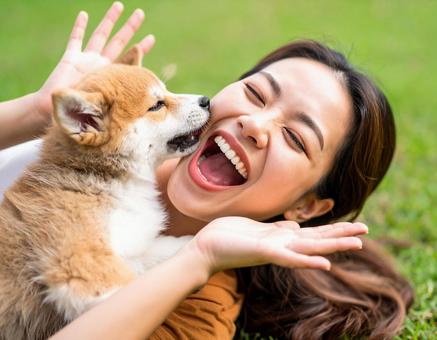 芝生の上で子犬と大笑いの写真
