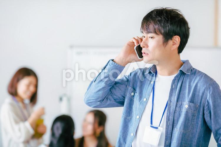 スマホを持つカジュアルな服装のビジネスマン スマホ,スマートフォン,デザイナーの写真素材