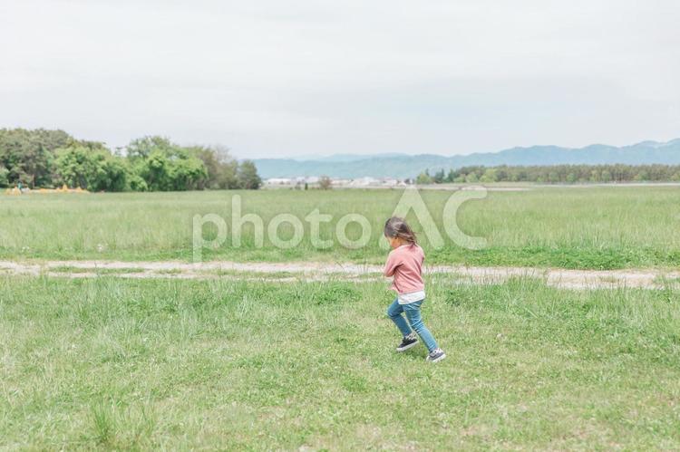 広い公園でおもちゃを持って走り回る子供 子供,女の子,子どもの写真素材