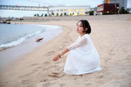砂浜に座って海を眺める女性 女性,海岸,秋の写真素材