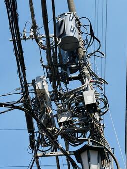 青空と複雑に交差する電柱・電線 電柱,電線,柱上変圧器の写真素材